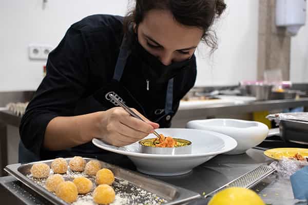 Alumna del Culinary Institute of Barcelona emplatando un plato de comida creativo